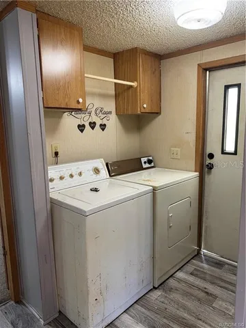 a utility room with cabinets washer and dryer