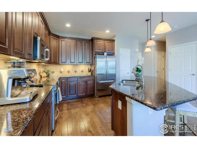 a kitchen with granite countertop a sink stainless steel appliances and cabinets
