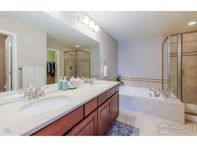 a spacious bathroom with a bathtub shower sink double and mirror