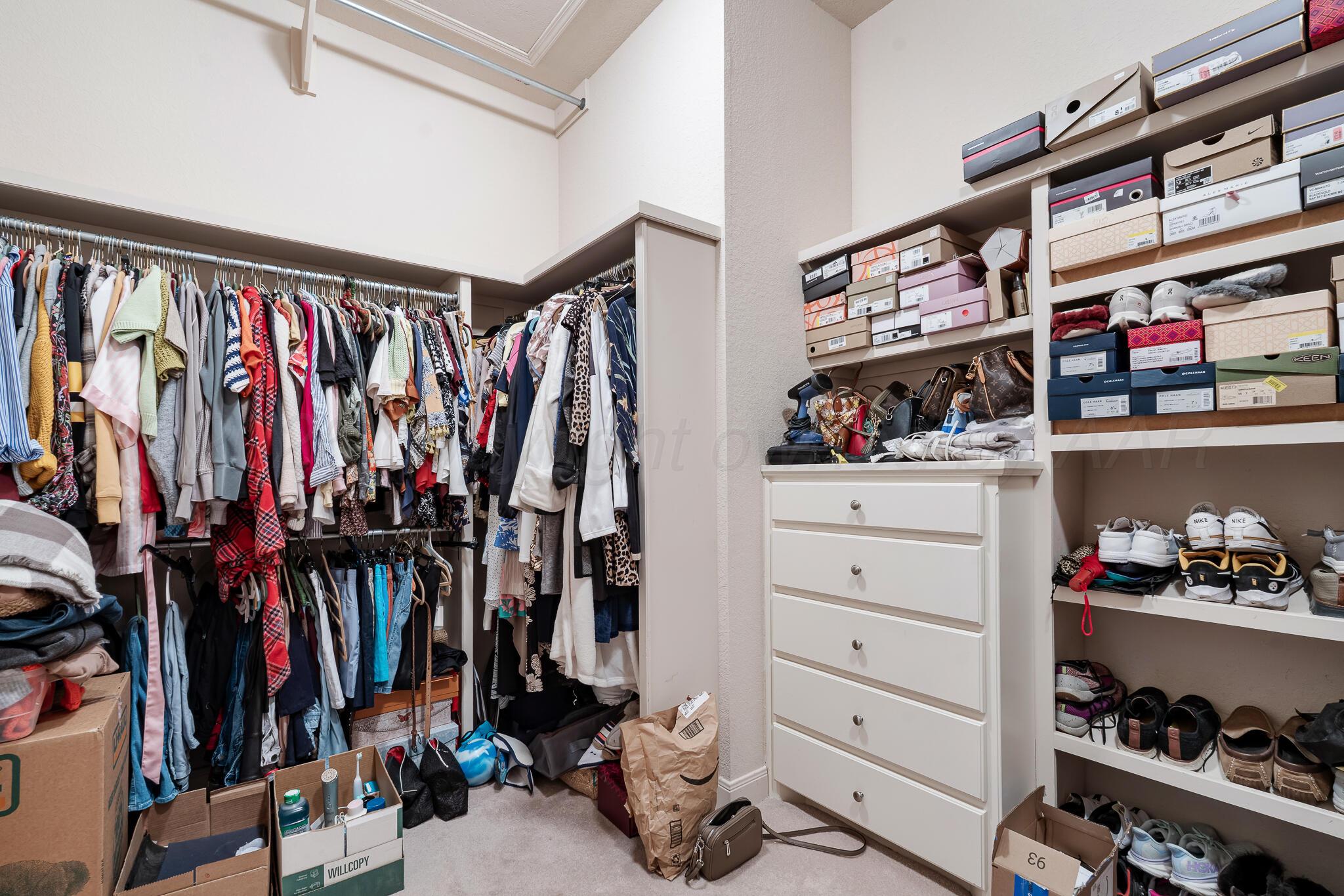 5008 Wesley Road Amarillo, TX 79119 - Photo 24 of 47 a view of walk in closet with clothes and shoes