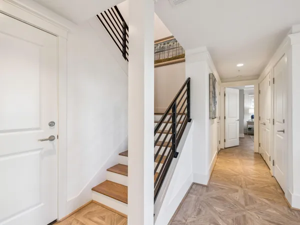 a view of a hallway with wooden floor and entryway