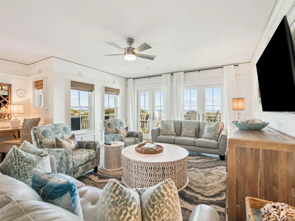 a living room with furniture a flat screen tv and a large window