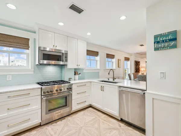 a kitchen with white cabinets stainless steel appliances and sink