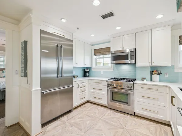 a kitchen with stainless steel appliances granite countertop a refrigerator a stove and a sink