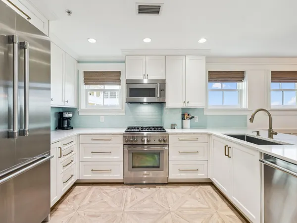 a kitchen with stainless steel appliances granite countertop a stove a sink and a refrigerator