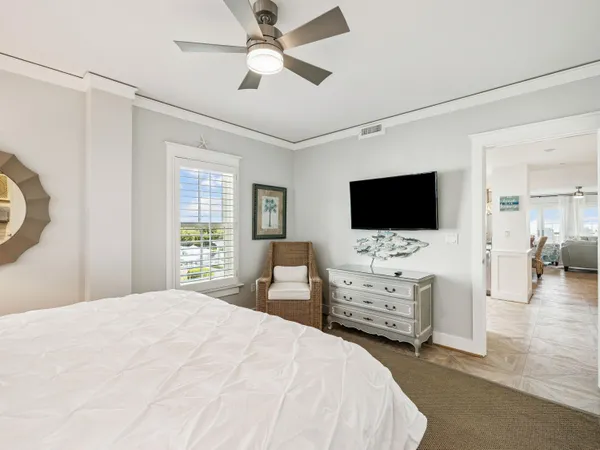 a bedroom with a bed flat screen tv and a window