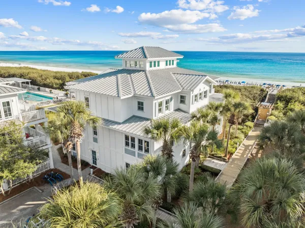 an aerial view of residential houses with outdoor space and ocean view