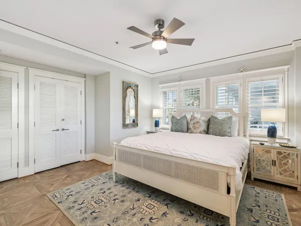 a room with a large bed and a chandelier fan