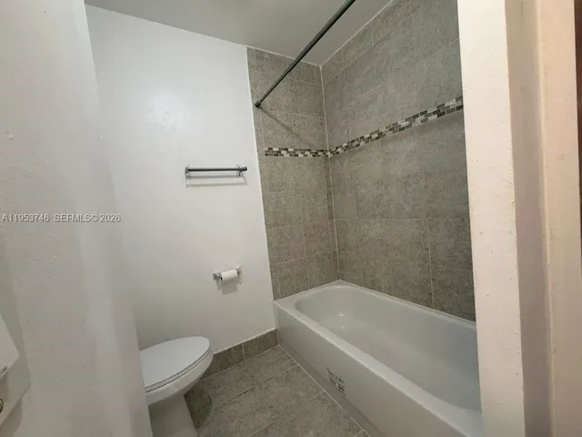 a white bath tub sitting next to a toilet