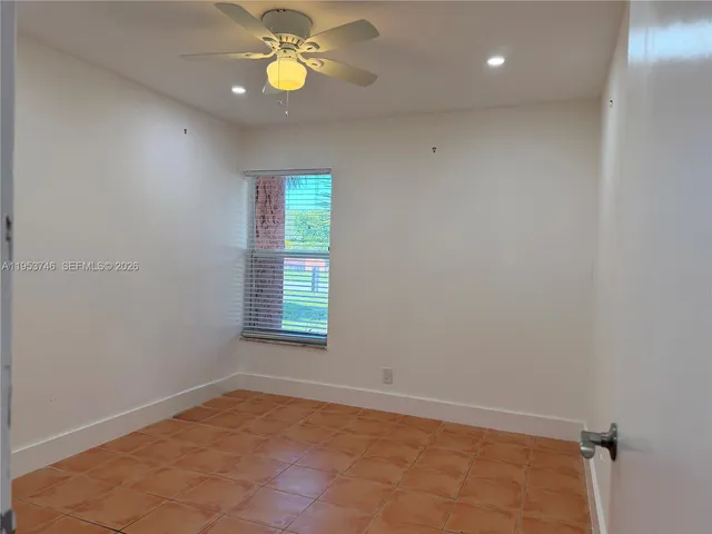 an empty room with a window and a ceiling fan