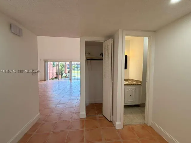 a view of a hallway with bathroom and wooden floor