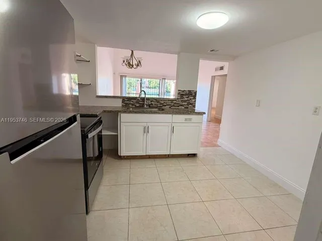 a kitchen with stainless steel appliances granite countertop a sink and a refrigerator