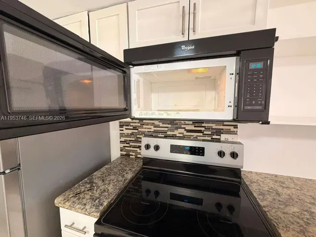 a stove top oven sitting inside of a kitchen