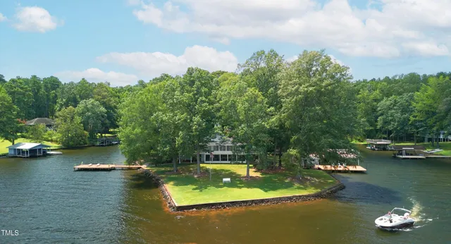 a view of swimming pool with lawn chairs and large trees