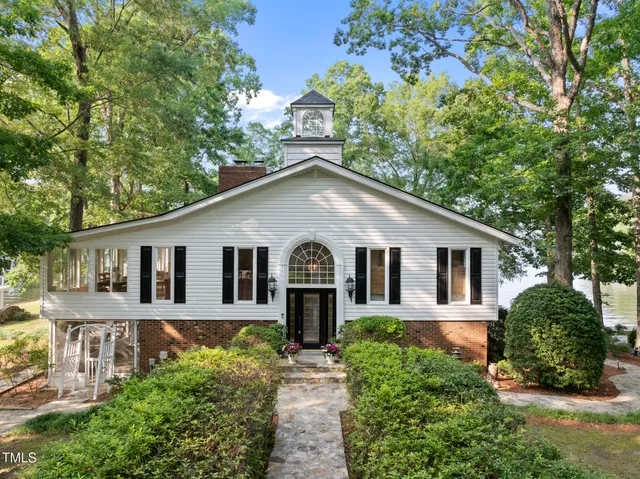 a kitchen with stainless steel appliances kitchen island granite countertop a table chairs in it and wooden floors