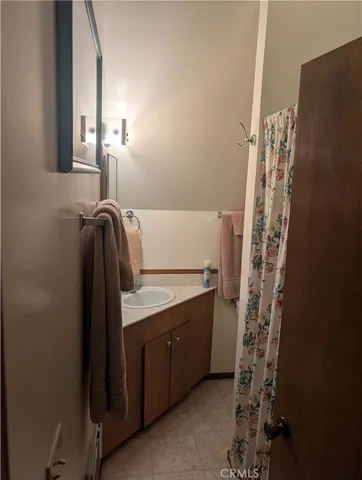 a bathroom with a granite countertop sink a vanity and a shower