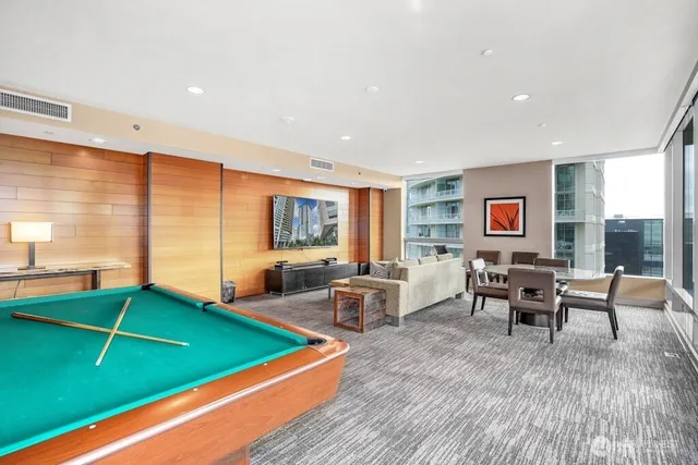 a living room with furniture pool table and a flat screen tv