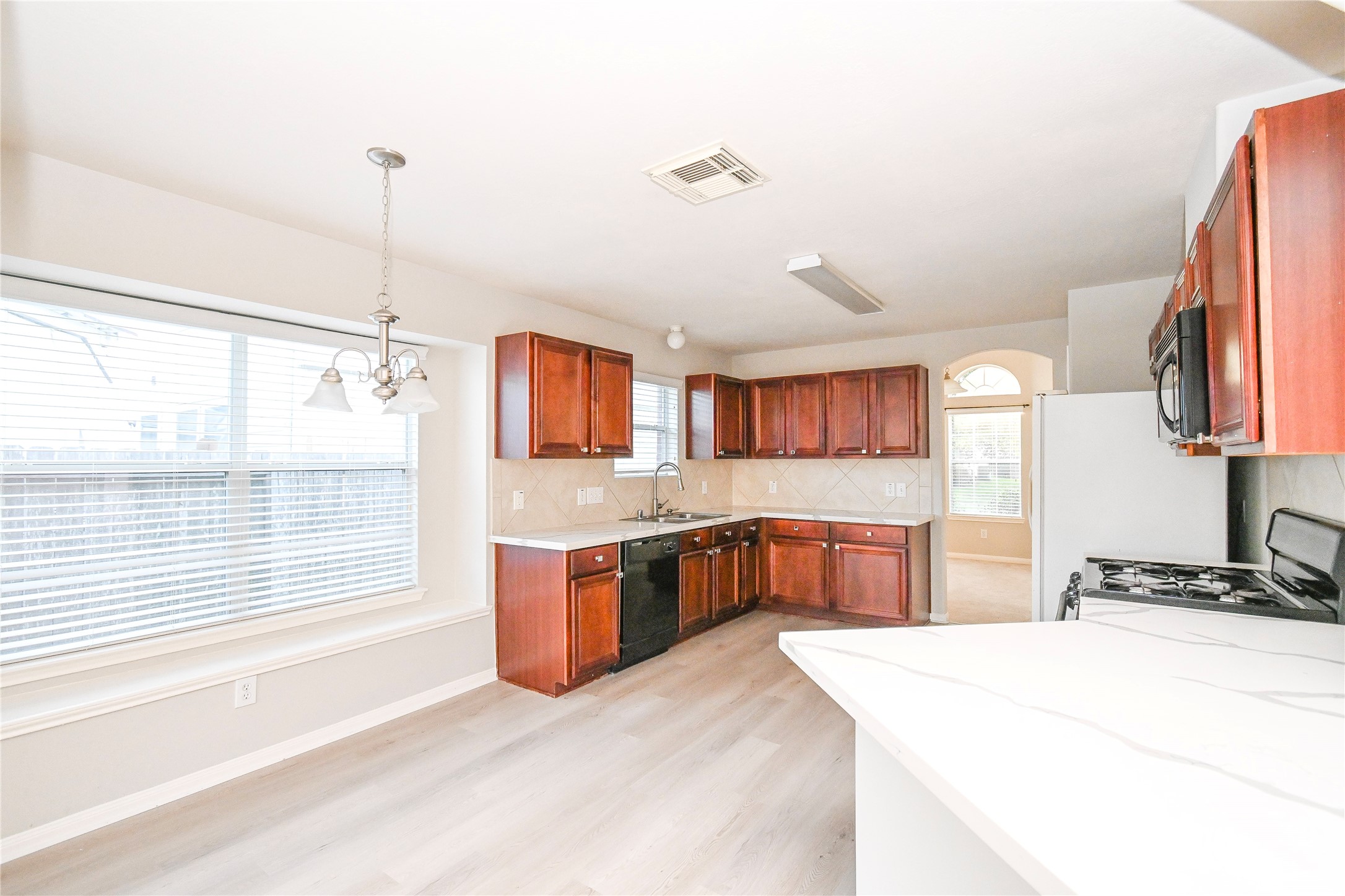 3111 Myrtle Ranch Drive Katy, TX 77494 - Photo 13 of 27 a large kitchen with stainless steel appliances kitchen island granite countertop a stove a sink dishwasher and a wooden cabinets