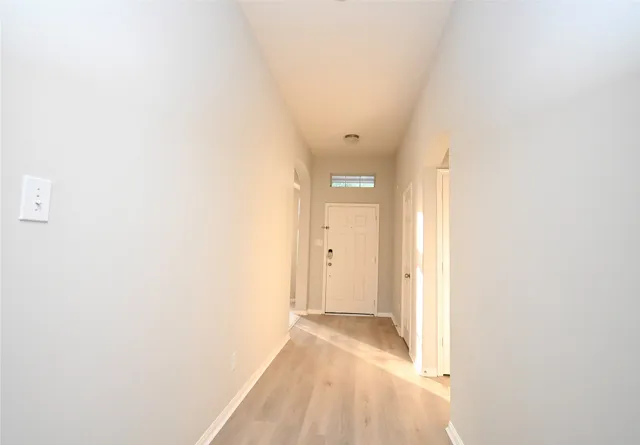 an empty room with windows and fireplace