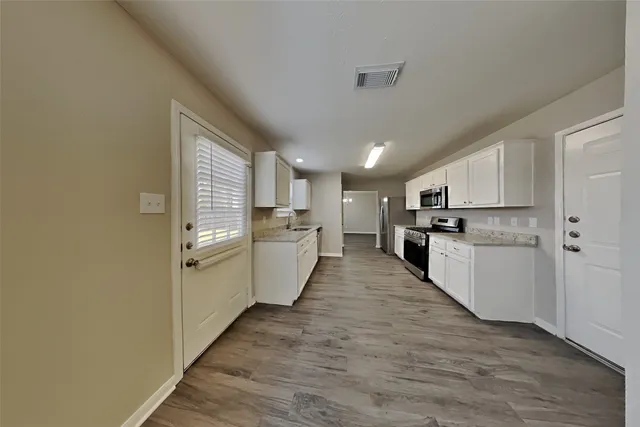 a view of a kitchen cabinets a sink and dishwasher wooden floor