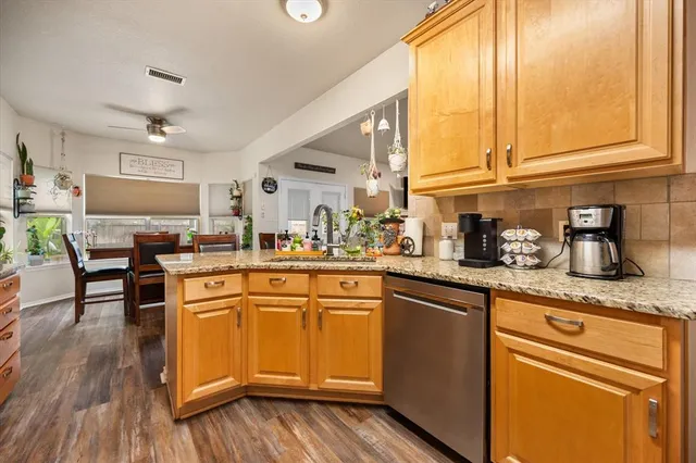 a kitchen with granite countertop wooden floors and white stainless steel appliances