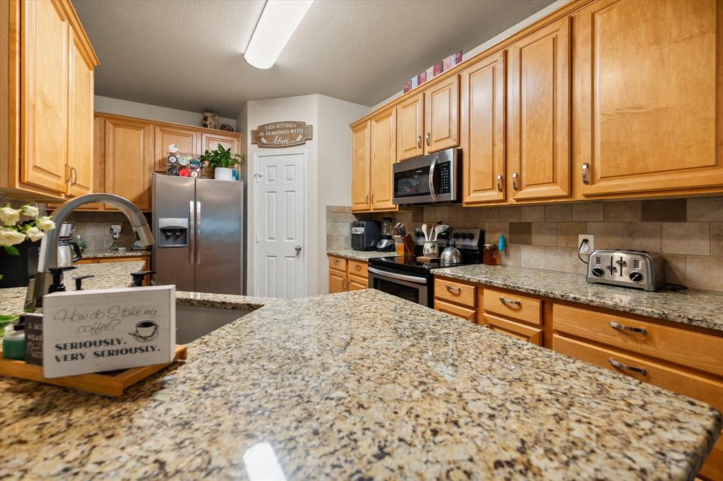 308 Faith Court Burleson, TX 76028 - Photo 8 of 40 a kitchen with stainless steel appliances granite countertop a stove sink and cabinets