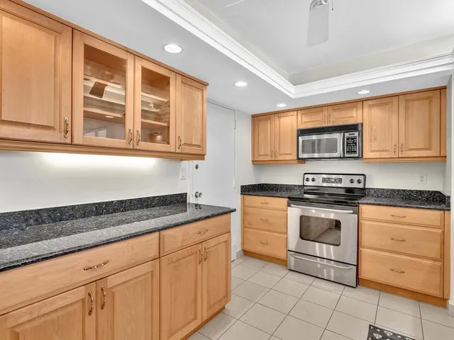 a kitchen with granite countertop a refrigerator and a sink