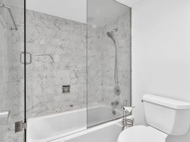 a front view of multi story residential apartment building with a yard and outdoor seating