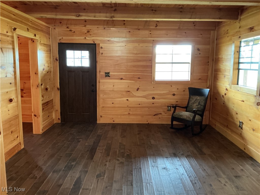 10550 Symmes Creek Road Adamsville, OH 43802 - Photo 9 of 21 Entrance foyer with wooden walls, beamed ceiling, and dark wood-style flooring