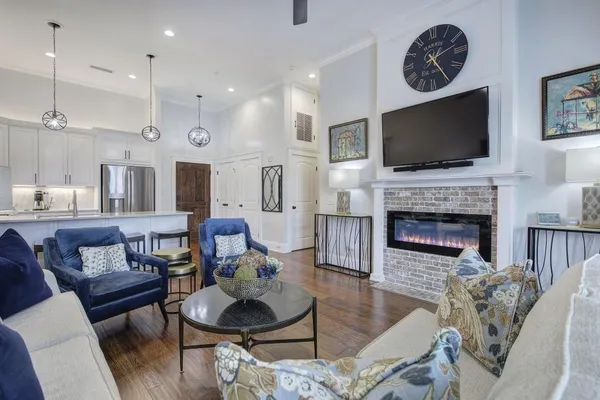 a living room with furniture a flat screen tv and a fireplace