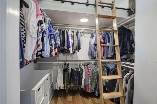 a view of walk in closet with clothes and shoes