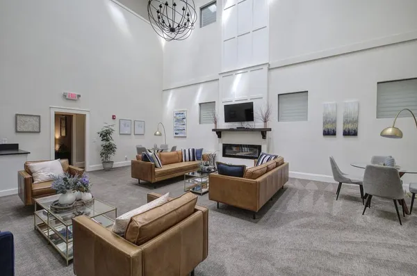 a living room with furniture a flat screen tv and kitchen view