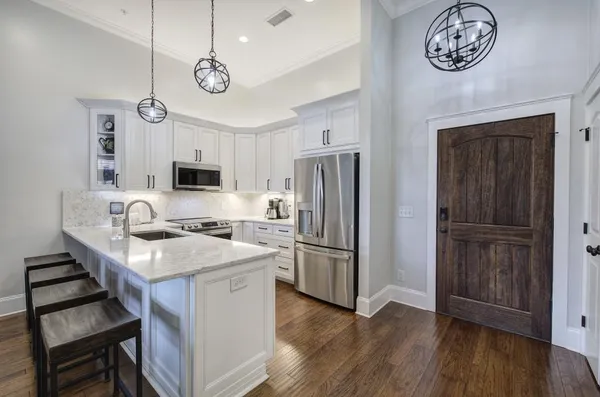 a kitchen with kitchen island a wooden floor and a refrigerator