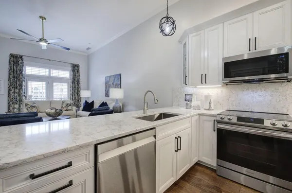 a kitchen with granite countertop a sink a stove and microwave