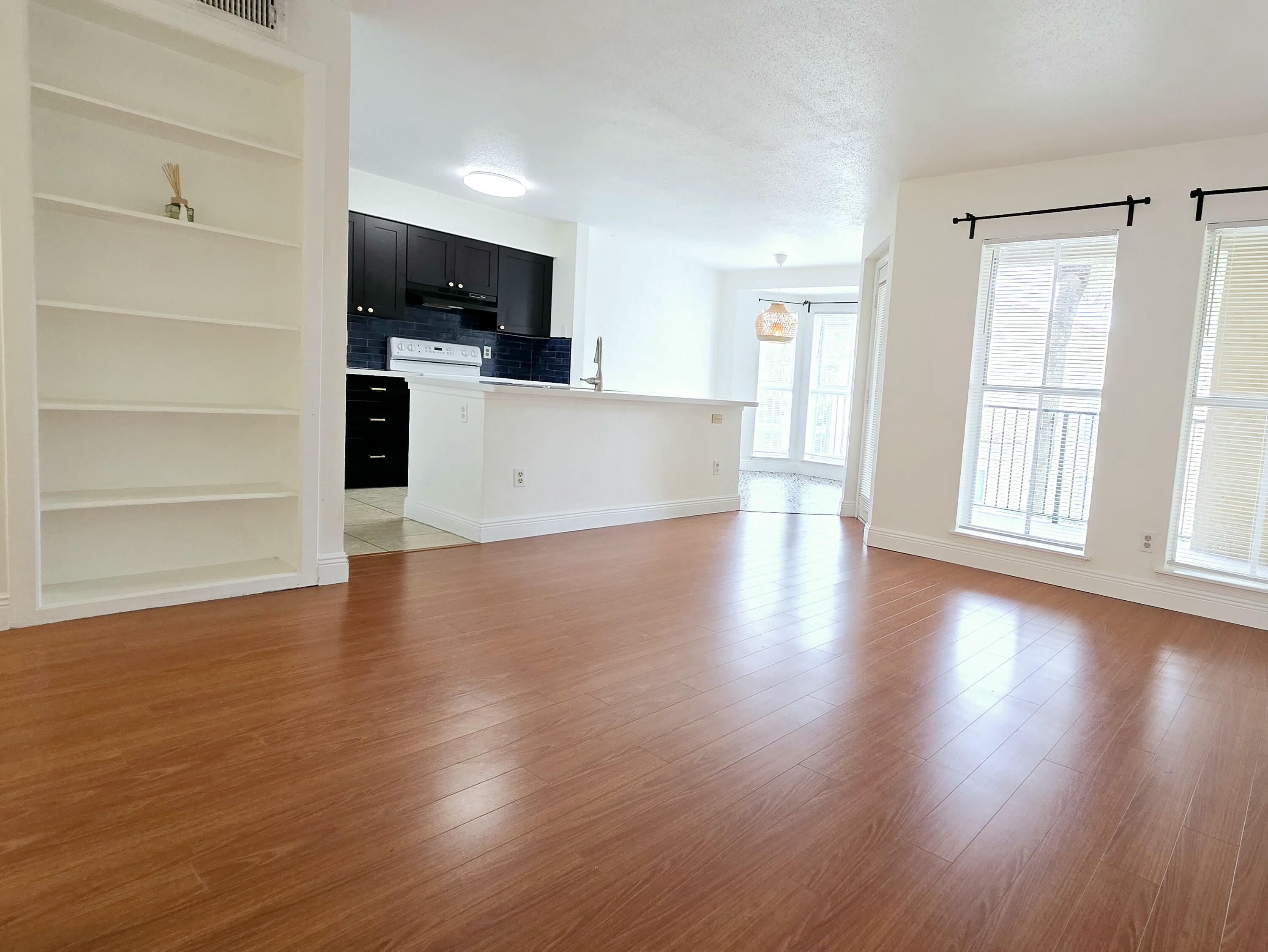 977 Riverside Drive, Unit 220 Coral Springs, FL 33071 - Photo 13 of 23 an empty room with wooden floor and windows