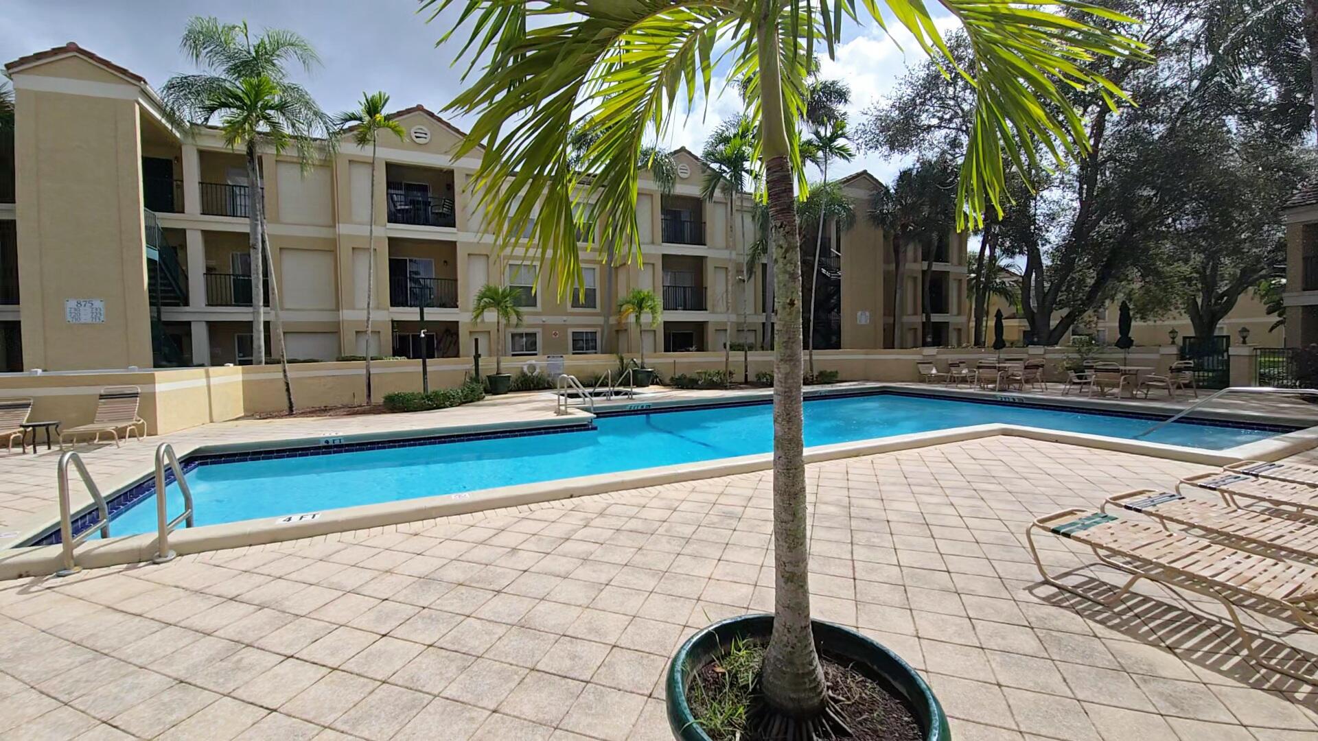 977 Riverside Drive, Unit 220 Coral Springs, FL 33071 - Photo 20 of 23 a swimming pool with outdoor seating and yard