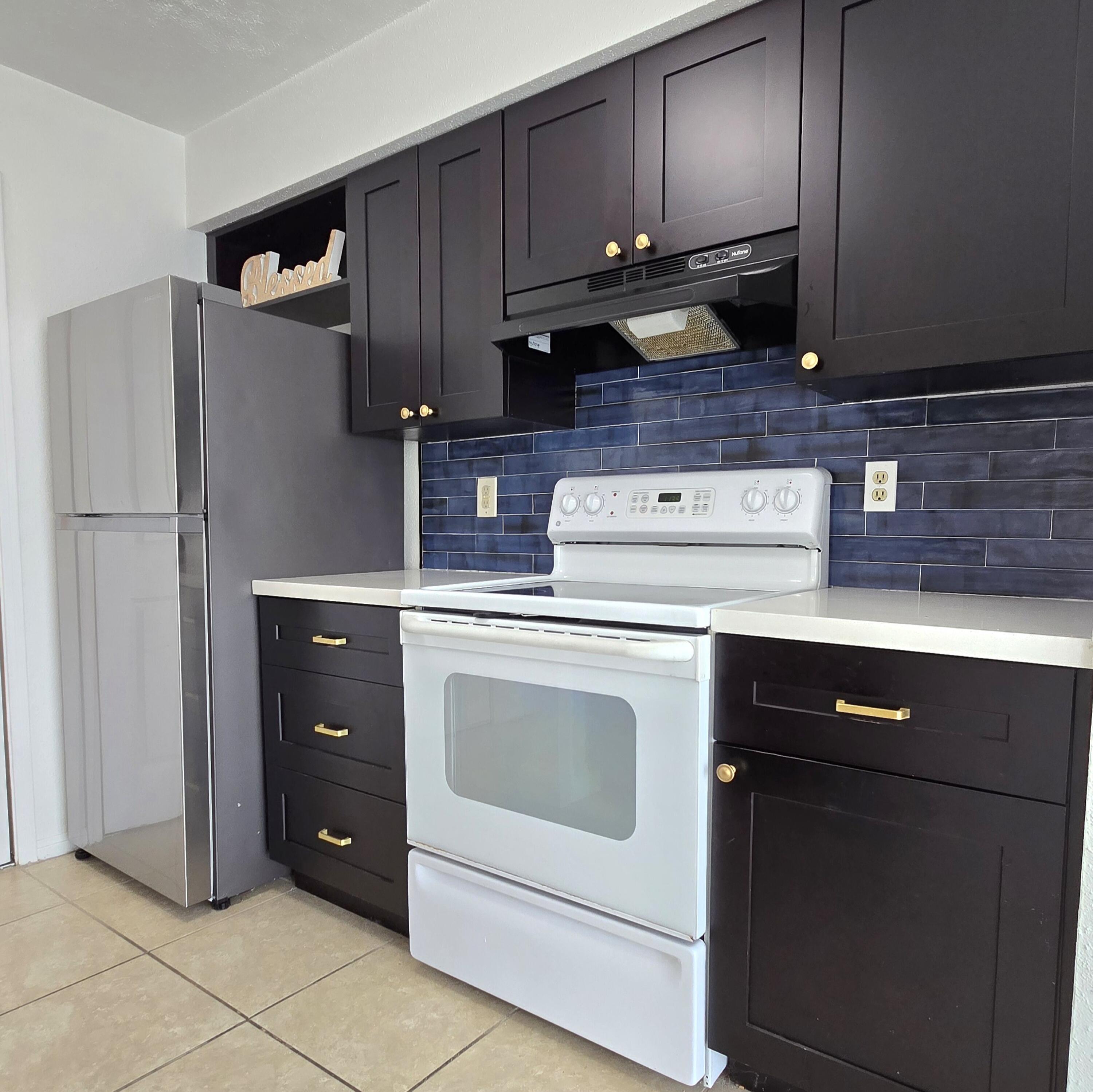 977 Riverside Drive, Unit 220 Coral Springs, FL 33071 - Photo 6 of 23 a kitchen with a stove and a refrigerator