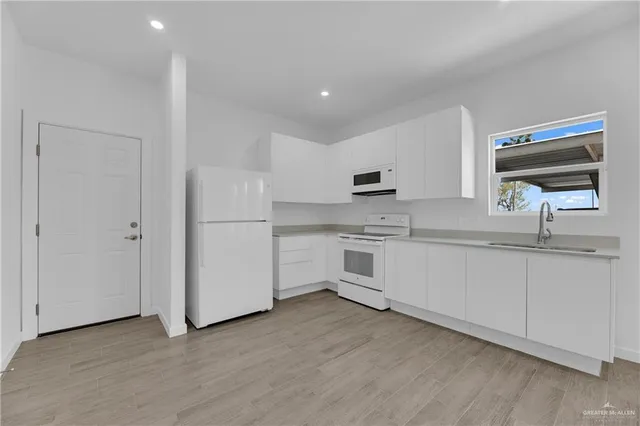 a kitchen with white cabinets and white appliances