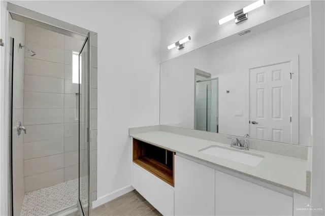 a bathroom with a granite countertop sink and a mirror