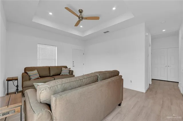 a living room with furniture and a ceiling fan