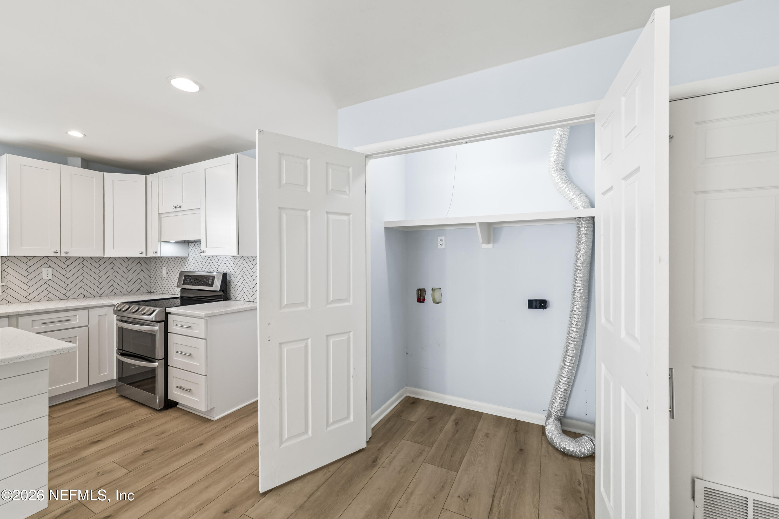 341 9th Street Atlantic Beach, FL 32233 - Photo 14 of 35 a kitchen with white cabinets and stainless steel appliances