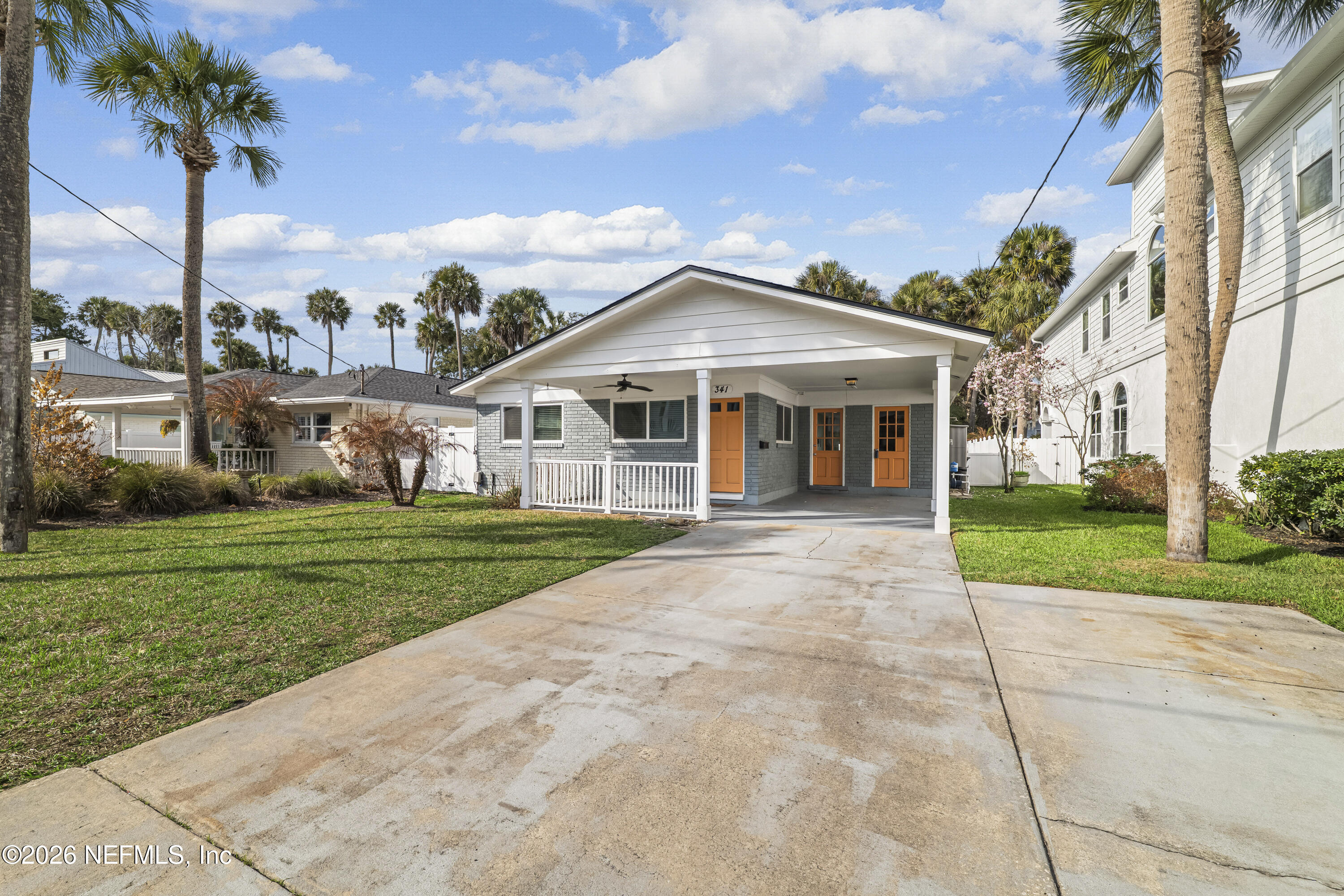 341 9th Street Atlantic Beach, FL 32233 - Photo 3 of 35 a view of a white house next to a yard with big trees