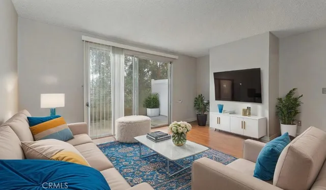 a living room with furniture a flat screen tv and a large window