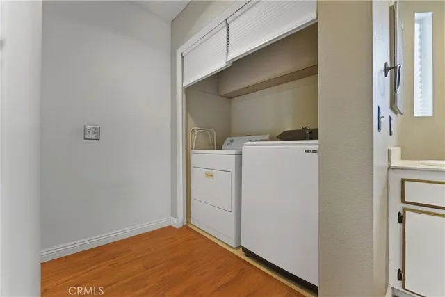 a view of an empty room with wooden floor and stairs