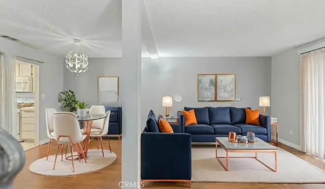 a living room with furniture a dining table and a chandelier