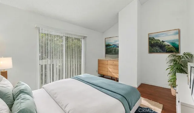 a bedroom with a bed and a potted plant