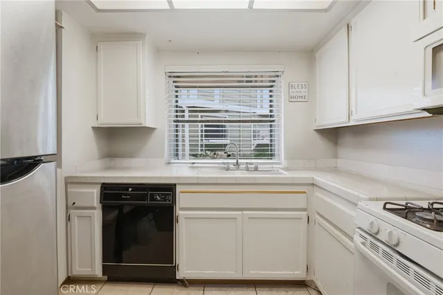 a kitchen with granite countertop white cabinets and a stove