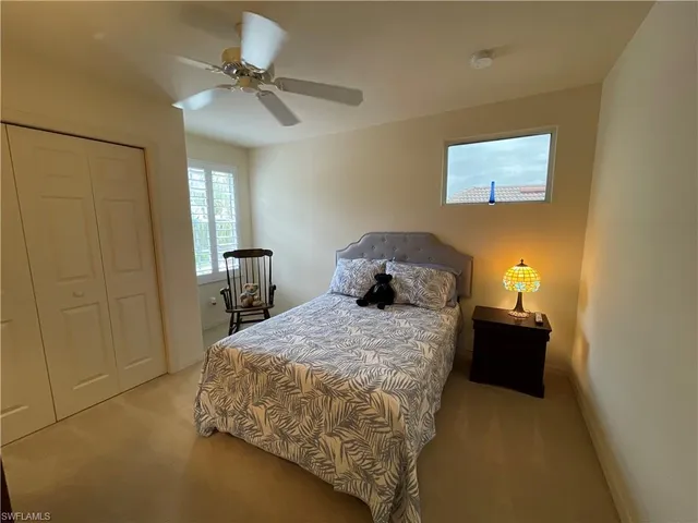 a bedroom with a bed and a chandelier fan