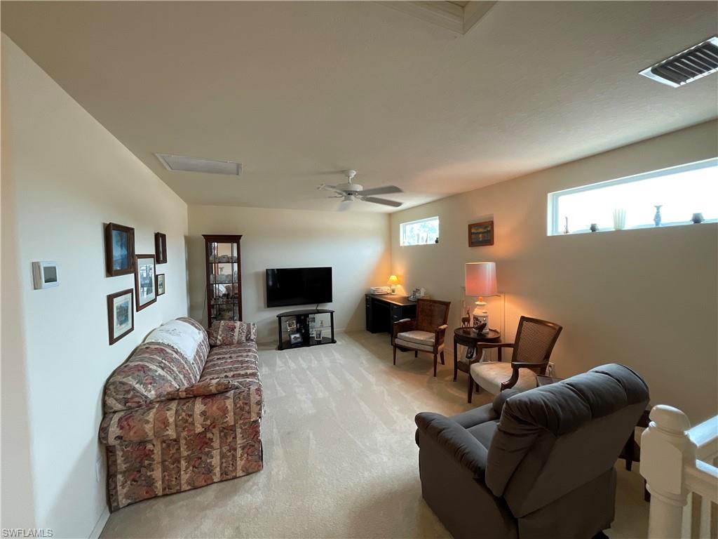 6478 Waverly Green Way Naples, FL 34110 - Photo 18 of 28 a living room with furniture a fireplace and a flat screen tv