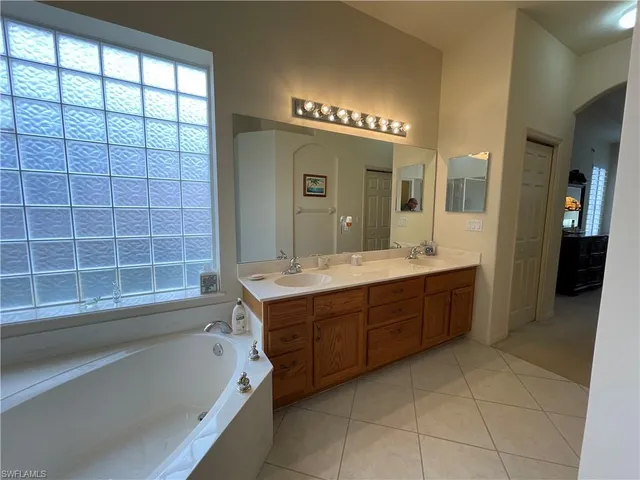 a bathroom with a tub shower and mirror